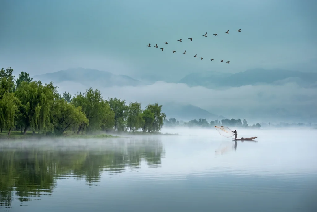 Lone fisherman boat on misty Wular Lake in Bandipora — one of Asia's largest freshwater lakes in Kashmir