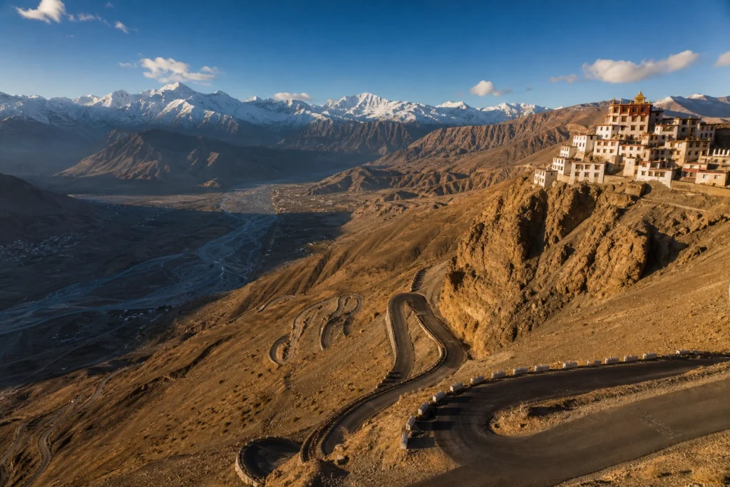 A panoramic view of Spiti Valley in May showing winding roads and snow-capped Himalayan peaks