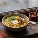 Warm khichdi bowl by a rainy window representing monsoon gut health India remedies